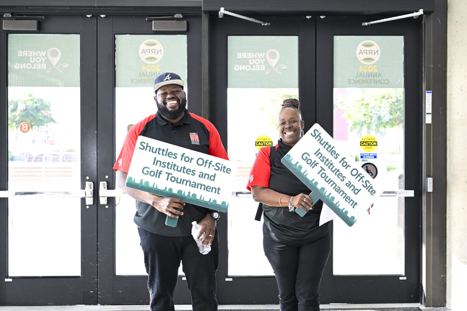 NRPA Annual Conference volunteers hold signs for shuttles