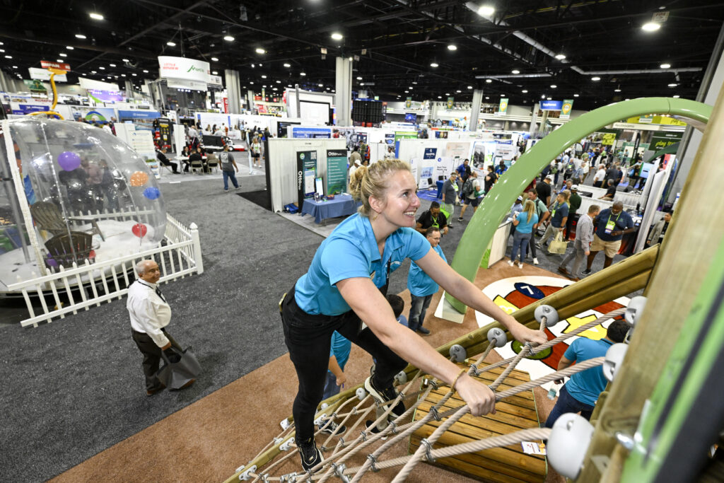 An attendee climbs a playground in the exhibit hall