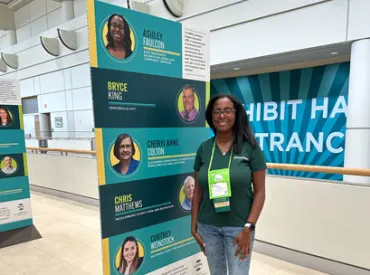 Ashely Faulcon (NRPA Annual Conference attendee) stands in front of signage